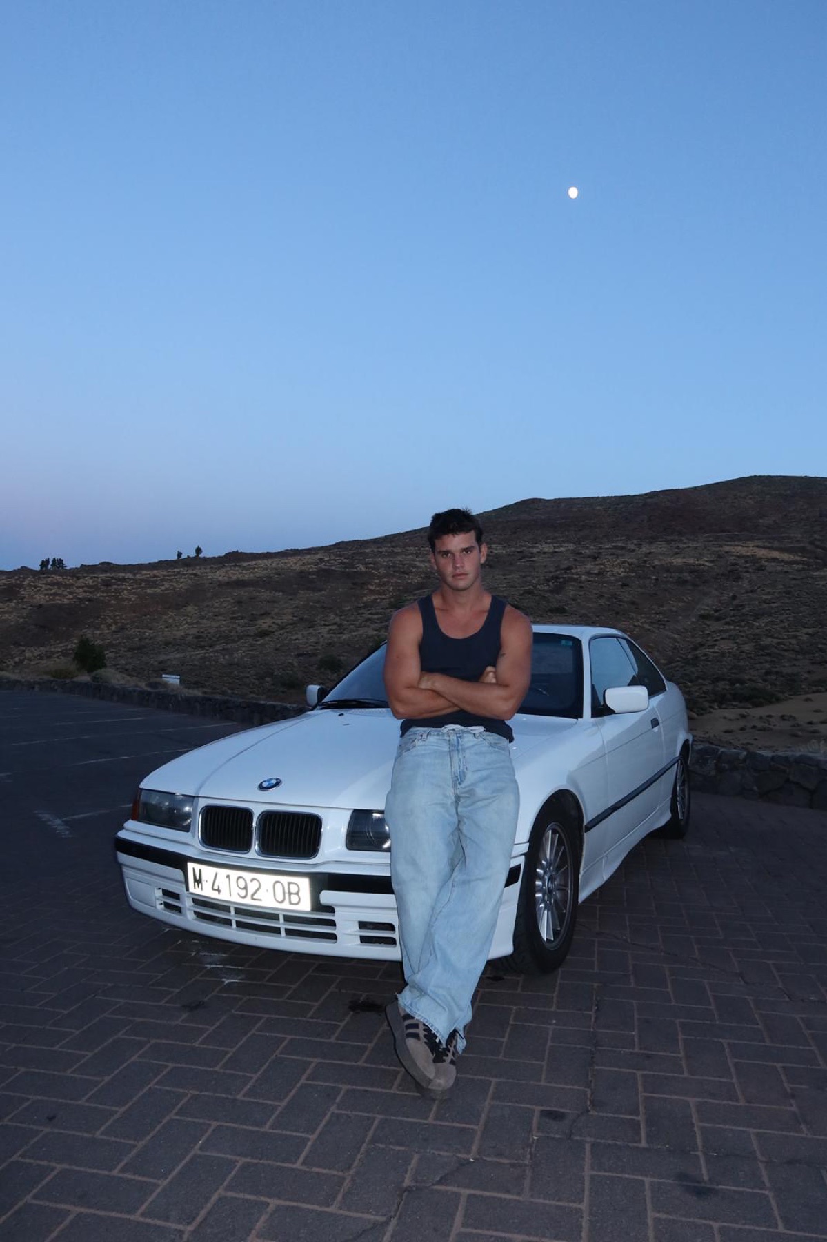 David apoyado en su BMW al atardecer